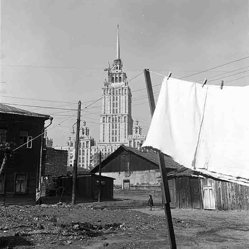 A monochrome photograph showcasing a building with laundry suspended on a line, illustrating a urban soviet union moment of everyday life