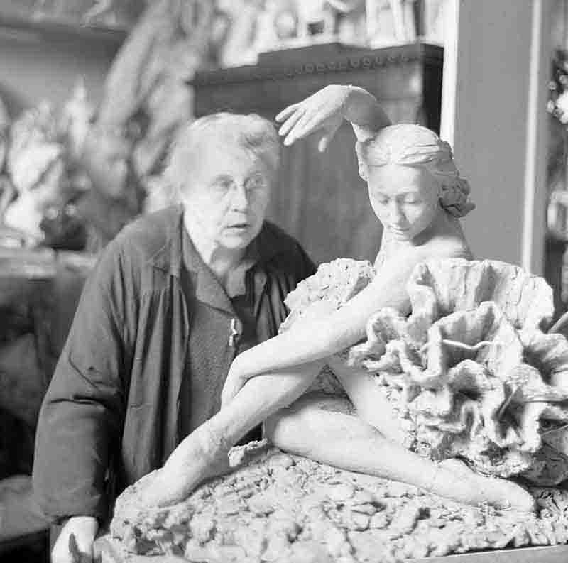 Sculptor Alexandrovna Yanson-Manizer stands beside a statue of ballet danc