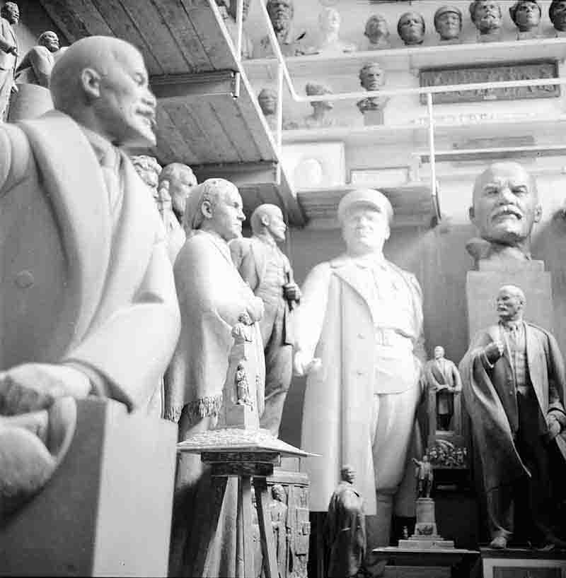 A black and white photograph showcasing various soviet union statues displayed in a atelier setting, highlighting their intricate details.