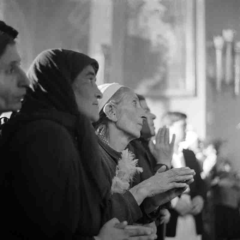 A congregation of people in Etchmiadzin Cathedral, united in prayer, embodying a moment of spiritual connection and devotion.