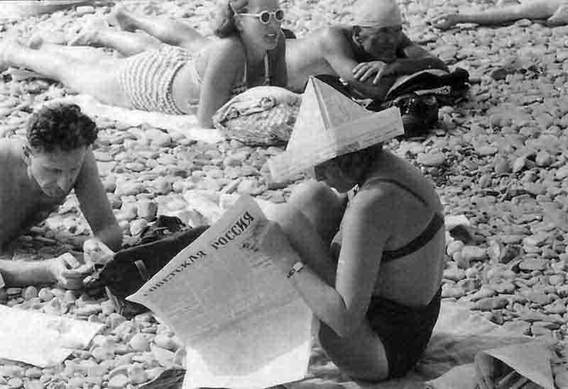 A monochrome image depicting individuals gathered on Sochi beach, with the ocean in the background and a serene atmosphere.