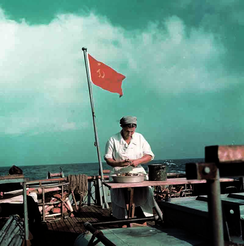 Fisherwoman on boat on the Ukrainian Black Sea shucking oysters